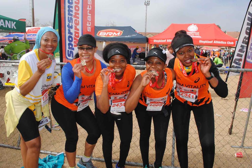 Group of runners in orange at the Wanderers Road Race