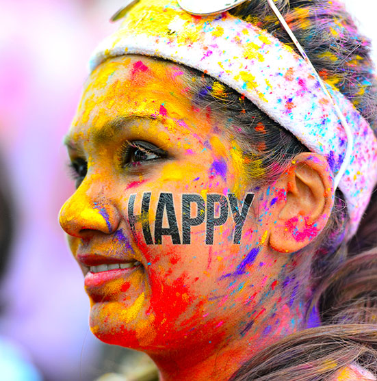 Smiling participant covered in colour powder at The Colour Run