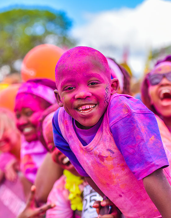 Child covered in pink colour powder at The Colour Run